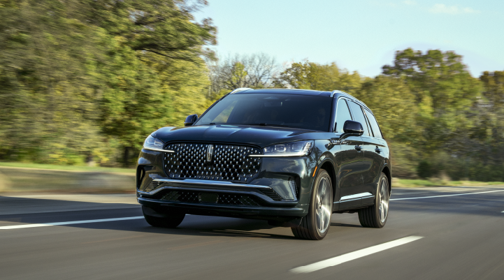 A 2025 Lincoln Black Label Aviator® SUV is being driven down a road lined with trees. | Johnson Brothers Lincoln in Temple TX