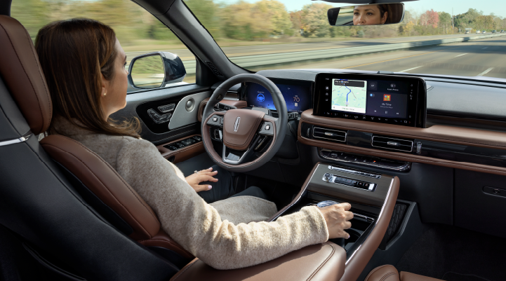 A woman is seen sitting in the driver’s seat of her 2025 Lincoln Aviator® SUV with her hands off the steering wheel. | Johnson Brothers Lincoln in Temple TX