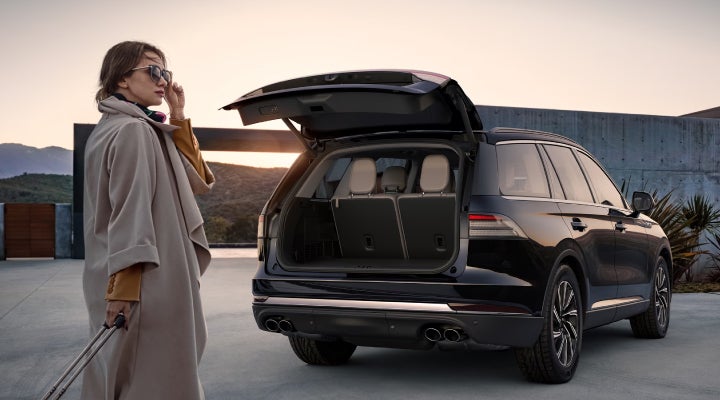 A woman approaches a 2026 Lincoln Aviator® SUV with its rear liftgate open. | Johnson Brothers Lincoln in Temple TX