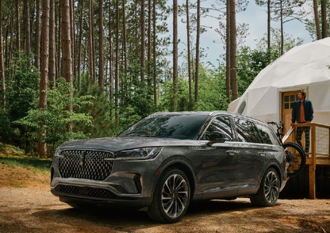 A 2027 Lincoln Aviator® is parked next to a high end glamping site. | Johnson Brothers Lincoln in Temple TX