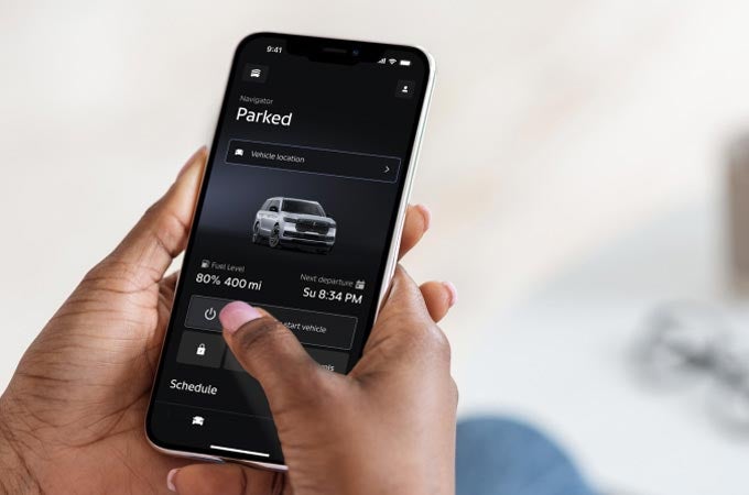 A woman holding a phone viewing the Lincoln app.