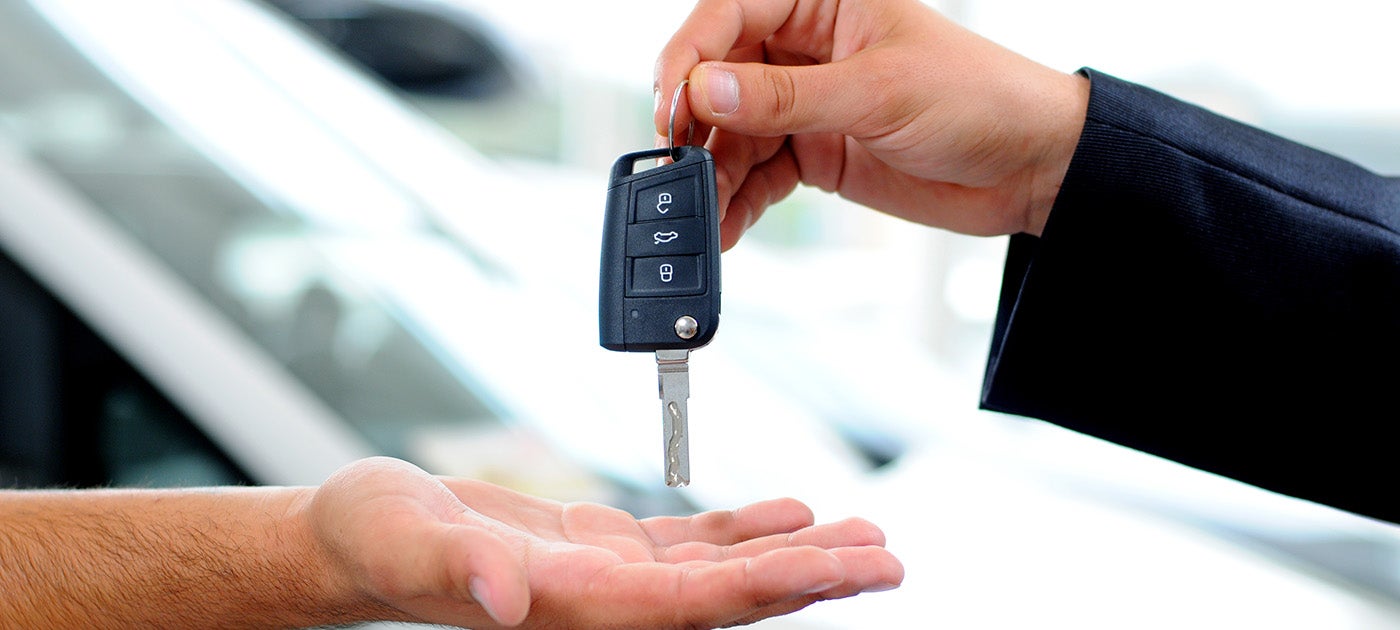 One person giving key of a vehicle to other